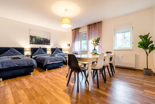 ein Wohnzimmer mit einem Tisch, Stühlen und einem Sofa in der Unterkunft Comodo Apartments Solingen in Solingen
