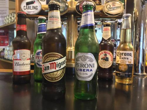 a group of beer bottles sitting on a bar at The Corner House Hotel in Annan