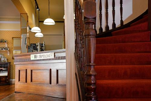 a stairway leading to a restaurant with a stair case at The Corner House Hotel in Annan