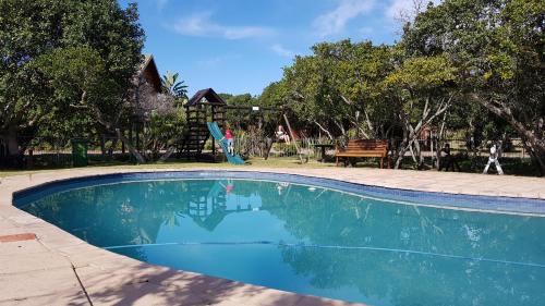 a swimming pool with a slide in a park at Pirates Creek Self-Catering Chalets in Wilderness