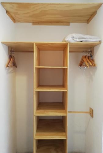 a shelf in a closet with wooden shelves at Romance City Hotel in Morelia