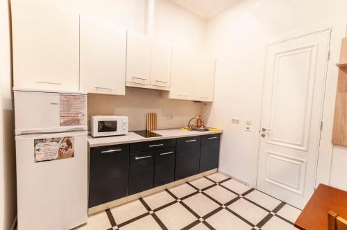 a kitchen with white cabinets and a white refrigerator at Wonderful flat on city center (Mukachivska 4/8) in Uzhhorod