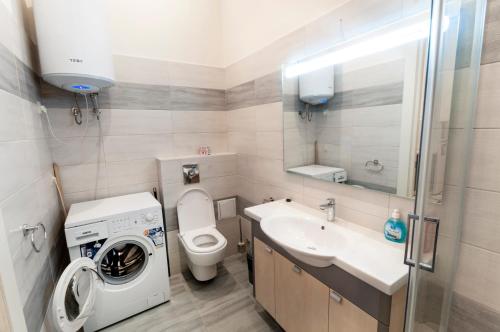 a bathroom with a washing machine and a sink at Wonderful flat on city center (Mukachivska 4/8) in Uzhhorod
