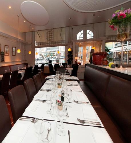 a dining room with a long table with glasses at Hotel Mille Colonnes in Leuven