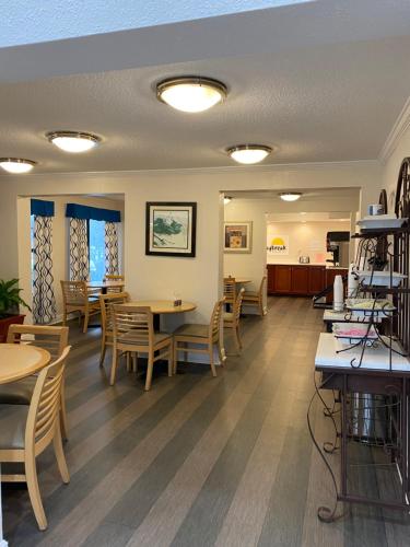 Days Inn & Suites Mobile في تيلمانز كورنر: غرفة انتظار في مطعم به طاولات وكراسي