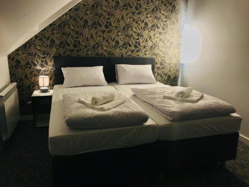 a bedroom with a bed with two pillows on it at R plius "Easy Kaunas" in Kaunas