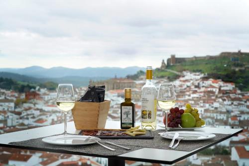 a table with two glasses of white wine and grapes at Barceló Aracena & Spa in Aracena