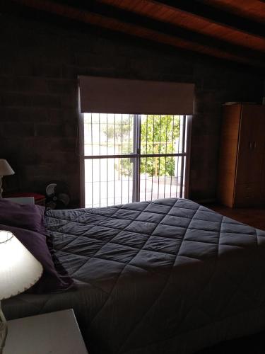 Un dormitorio con una cama grande y una ventana en CASA NOSTRA en Melincué
