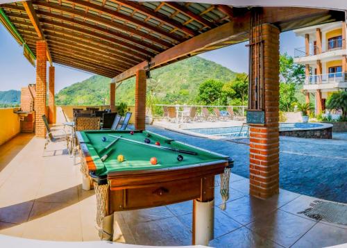 
a patio area with a pool and a pool table at Residencia Vitória Mar in Ubatuba
