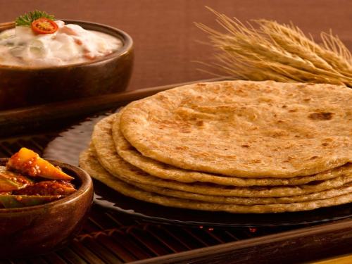 HarsilにあるMountain Village Stay - Dharali Heights Harsilのディップ付きのチャパティの山とディップのボウル