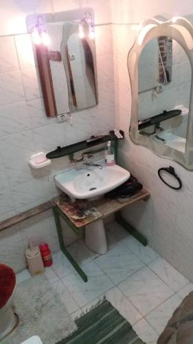 a bathroom with a sink and a mirror at At Home Hostel in Korçë