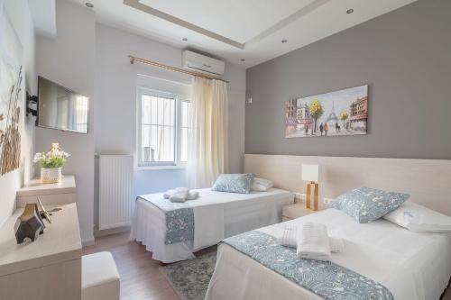 een slaapkamer met 2 bedden en een raam bij Kleio by Heloni Apartments in Athene