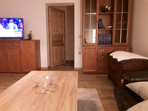 a living room with a coffee table and a tv at Ferienwohnung auf dem Land in Dittersbach