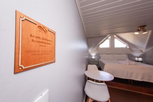 a room with two beds and a sign on the wall at Pousada Colina Verde in Garopaba
