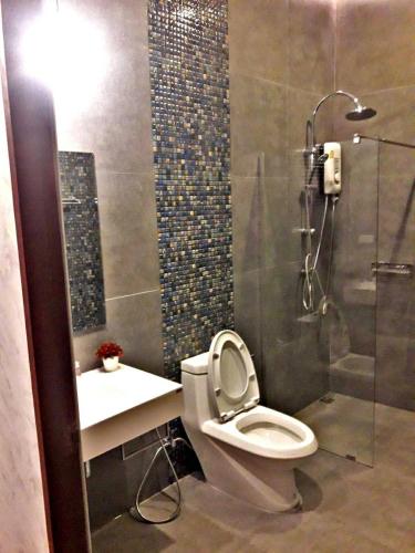 a bathroom with a toilet and a shower and a sink at PoolVilla Chaam NL in Cha Am