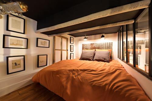 a bedroom with a large orange bed in a room at Les Petites Suites Dieppoises - Le Petit Prince A Dit in Dieppe