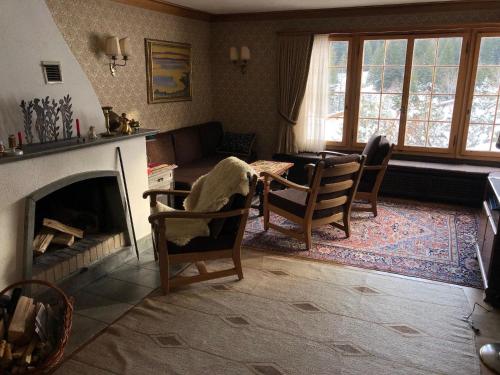 a living room with a fireplace and a table and chairs at La Ruada (701 Bo) in Lenzerheide