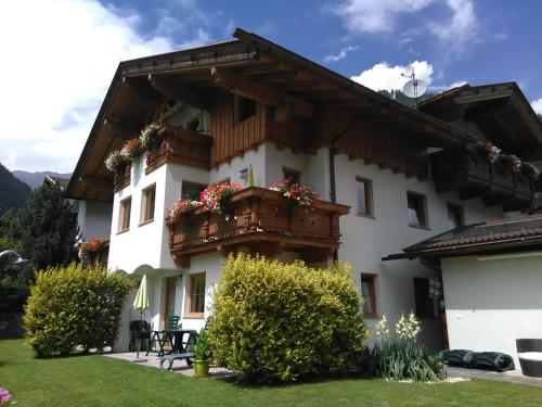 ein Gebäude mit einem Balkon mit Blumen darauf in der Unterkunft Landhaus Müller in Neustift im Stubaital