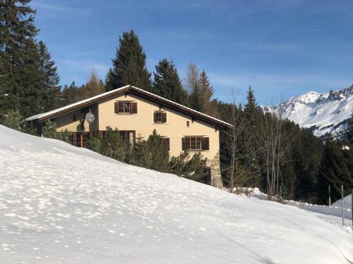 a house on top of a snow covered slope at La Ruada (701 Bo) in Lenzerheide