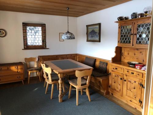uma sala de jantar com uma mesa de madeira e cadeiras em La Ruada (701 Bo) em Lenzerheide
