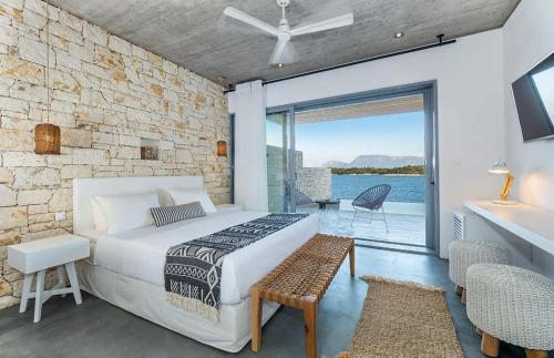 a bedroom with a bed and a view of the water at KEROMOUSSI SEASIDE BOUTIQUE HOTEL - Adult only in Meganisi