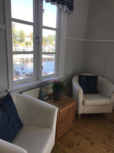 a living room with two white couches and two windows at Vandrarhemmet Lotsen in Dalarö