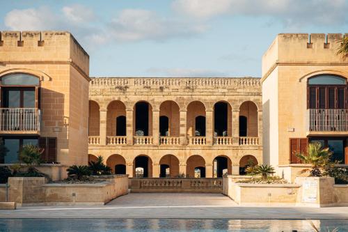 a large brick building with arches and a courtyard at Cosy apartment in Historic Fort Chambray, Gozo in Mġarr