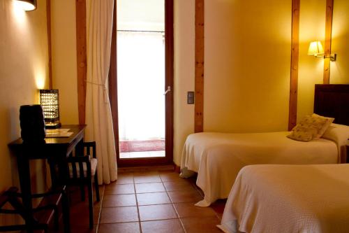 a hotel room with two beds and a window at Mas del Bot in Valderrobres
