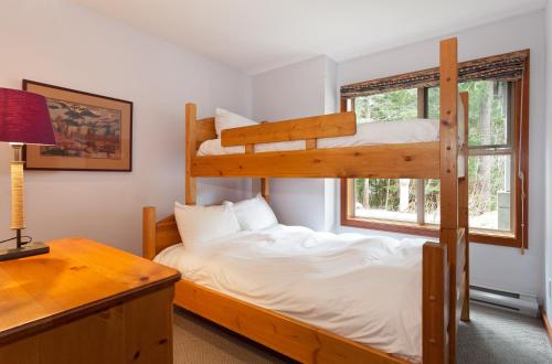 1 Schlafzimmer mit 2 Etagenbetten und einem Schreibtisch in der Unterkunft Treeline Townhome by Whistler Premier in Whistler