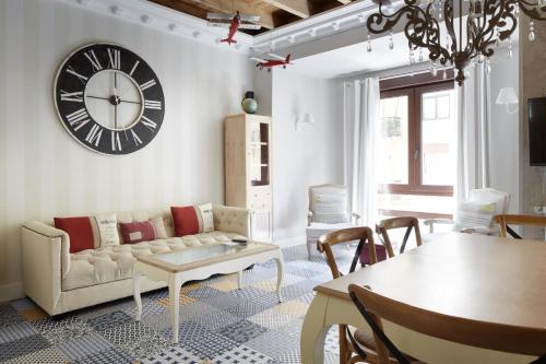 a living room with a couch and a clock on the wall at Kursaal - Basque Stay in San Sebastián