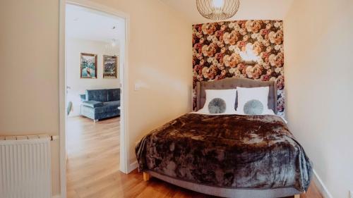 a bedroom with a bed with a floral wall at Apartament Silence Triventi Szmaragd in Karpacz