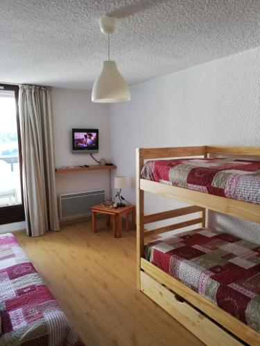 a bedroom with two bunk beds and a tv at les saisies ;loue a la semaine in Hauteluce