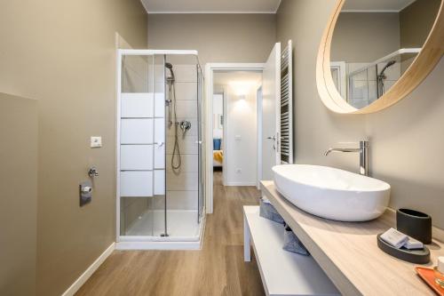 a bathroom with a white sink and a shower at Emilia Suite Young in Modena