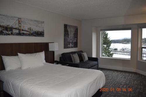 a hotel room with a bed and a chair and a window at High Point Resort in Quathiaski Cove