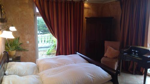 a bedroom with a bed with white pillows and a window at Gästehaus Chalet Ochtrup in Ochtrup