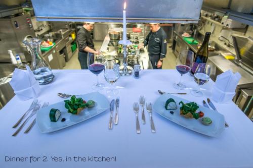 a table with two plates of food and wine glasses at Sporthotel Pontresina in Pontresina
