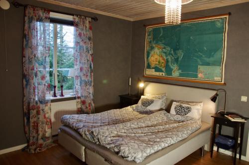 ein Schlafzimmer mit einem Bett und einem großen Fenster in der Unterkunft Hidingsta gård B&B in Örebro