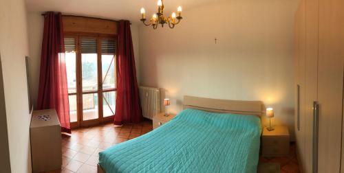 una camera da letto con un letto con lenzuola blu e una finestra di Villa Ponte a San Damiano dʼAsti
