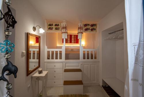 Baño pequeño con armarios blancos y espejo en Maria's Anatolia Villa, en Karpathos