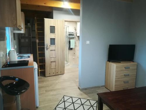 um quarto com uma cozinha com uma televisão numa cómoda em Domek Bobrowe Zacisze w Górach Sokolich em Karpacz