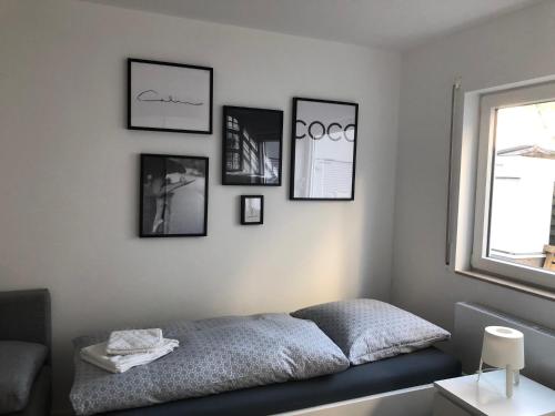 a bedroom with a bed with four pictures on the wall at Deluxe Apartments Messe Flughafen in Leinfelden-Echterdingen