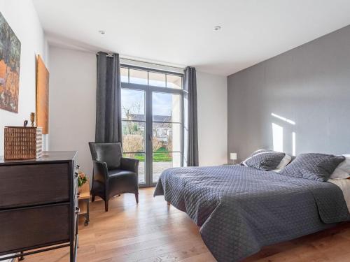 a bedroom with a bed and a chair and a window at Vintage Holiday Home in Escalles with Garden in Escalles