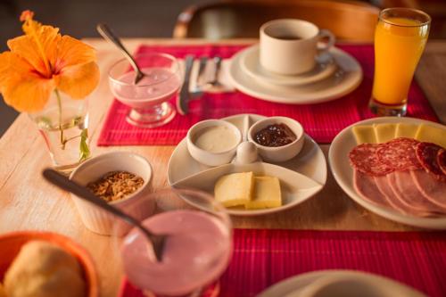 a table topped with plates of food on a table at Pousada Colina Verde in Garopaba