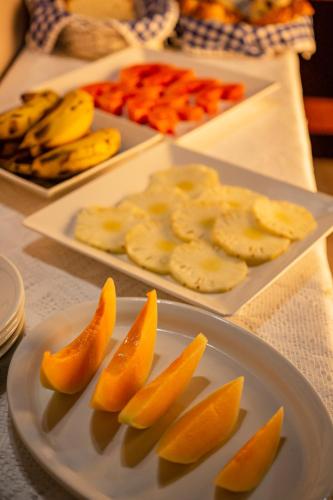 a plate with oranges and bananas on a table at Pousada Colina Verde in Garopaba