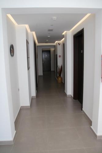 a hallway in a building with white walls and tile floors at Sonia Hotel & Suites in Kos