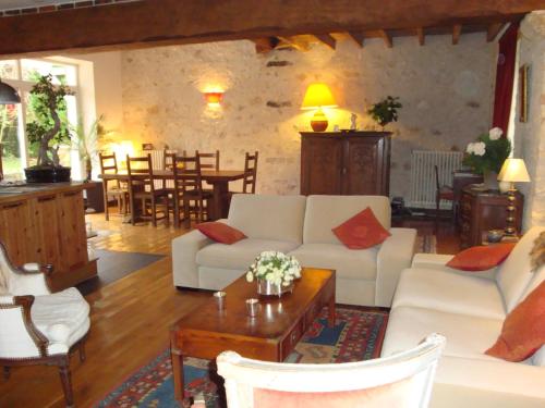 a living room with a white couch and a table at Les Ecureuils in Bougligny