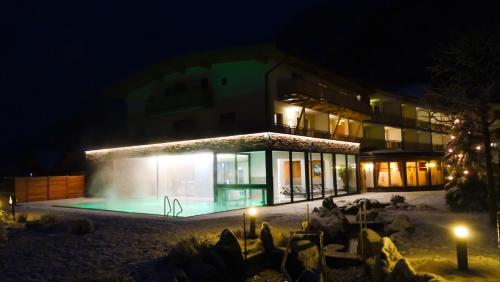 a building with a swimming pool at night at Hotel Römerhof in Fusch an der Glocknerstraße