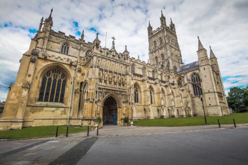 an old cathedral with a tower and a large building at Chesterton Court Apartment in Gloucester