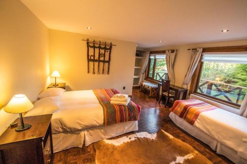 a hotel room with two beds and a window at Hostería Tercera Barranca in Torres del Paine