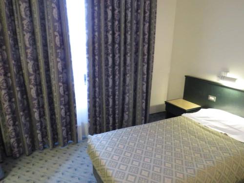 a bedroom with a bed and a window with curtains at Hotel Turandot in Grisignano di Zocco